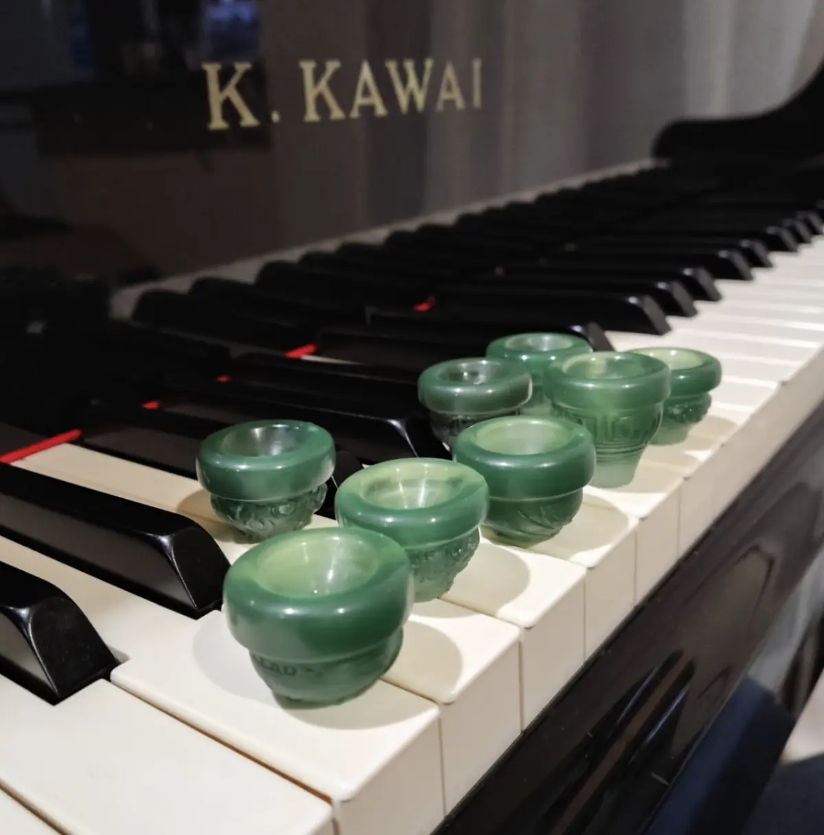 Collection of green Phoenix Brass mouthpieces displayed on piano keys